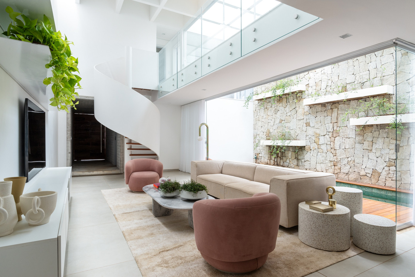 Khu vực sảnh phòng khách và hồ bơi ngoài trời chiếm một không gian có chiều cao gấp đôi để đón nắng, mang lại nguồn sáng cho ngôi nhà.