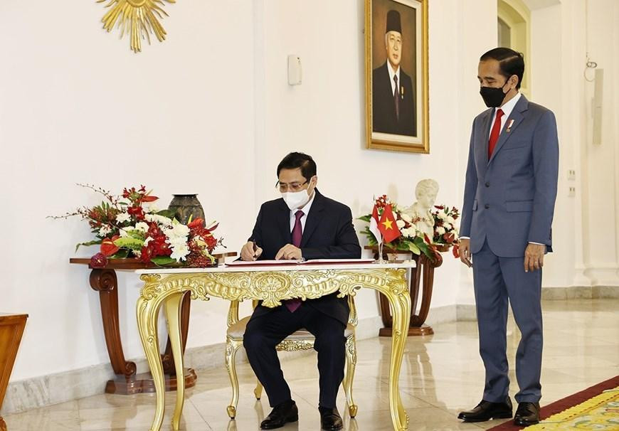 Thủ tướng Phạm Minh Chính ký sổ lưu niệm. Ảnh: Dương Giang/TTXVN