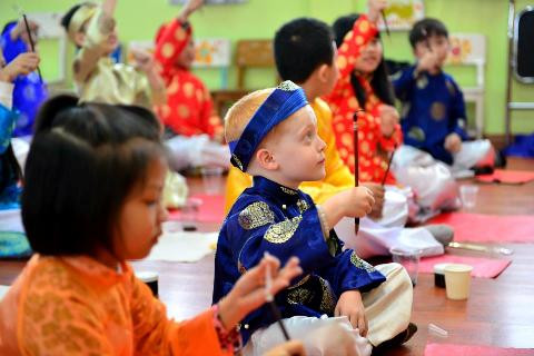 Đang say sưa lắng nghe thầy đồ hướng dẫn cách cầm bút lông 