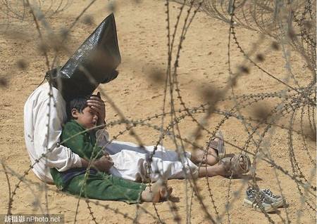 2003: Một người đàn ông Iraq vỗ về đứa con trai trong một trại giam tù nhân chiến tranh ở An Najaf