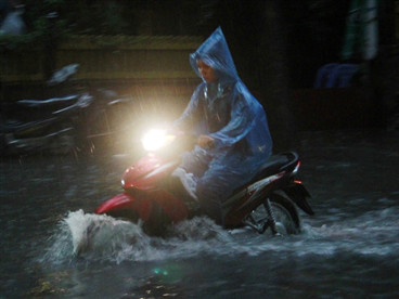 Người và phương tiện di chuyển khó khăn trên những đoạn đường chìm sâu trong nước ở Hà Nội tối 14-6. Ảnh: Xuân Tùng