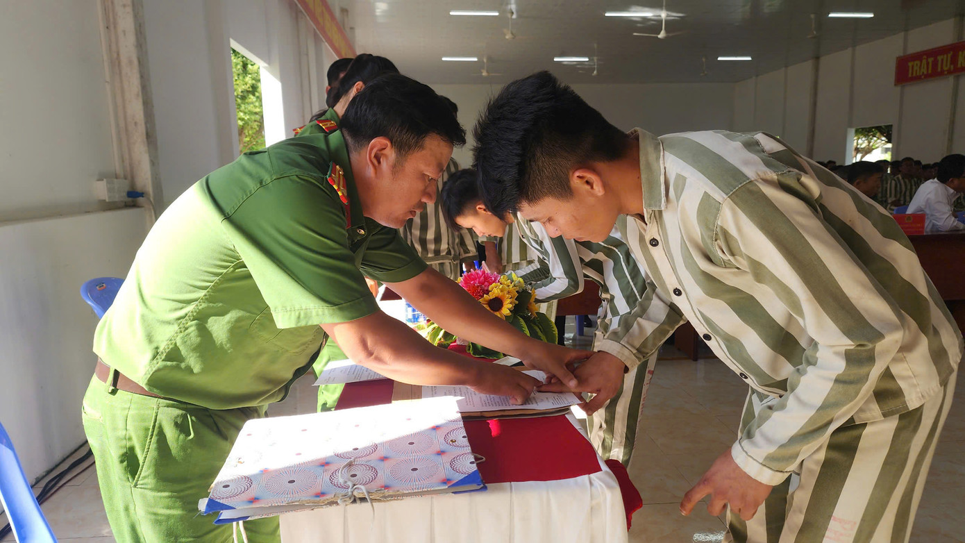 Cán bộ quản giáo làm thủ tục cho phạm nhân được đặc xá. Cán bộ quản giáo làm thủ tục cho phạm nhân được đặc xá.