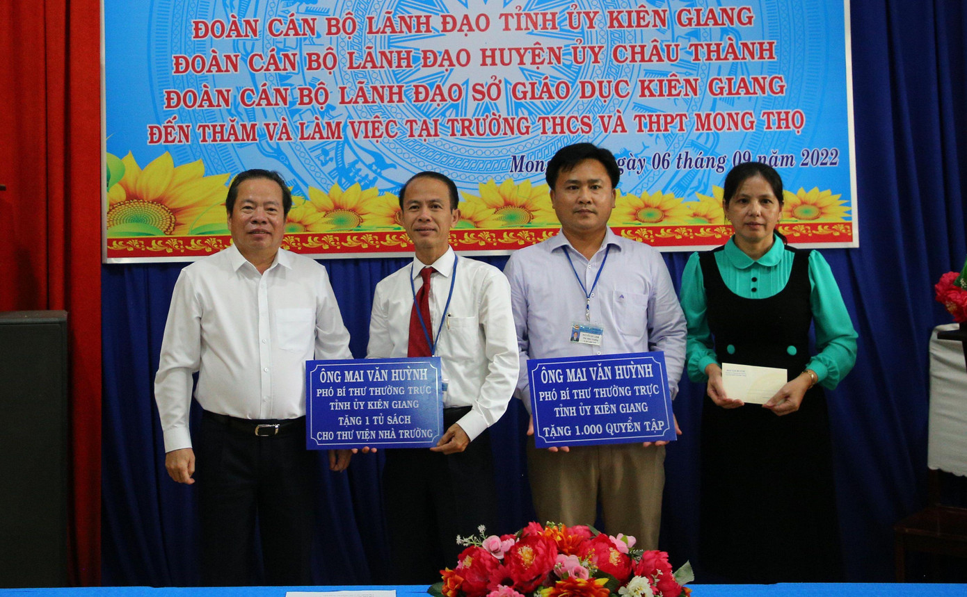 Ông Mai Văn Huỳnh - Phó Bí thư Tỉnh uỷ Kiên Giang (bên trái) trao bảng tượng trưng tủ sách thư viện cho nhà trường.