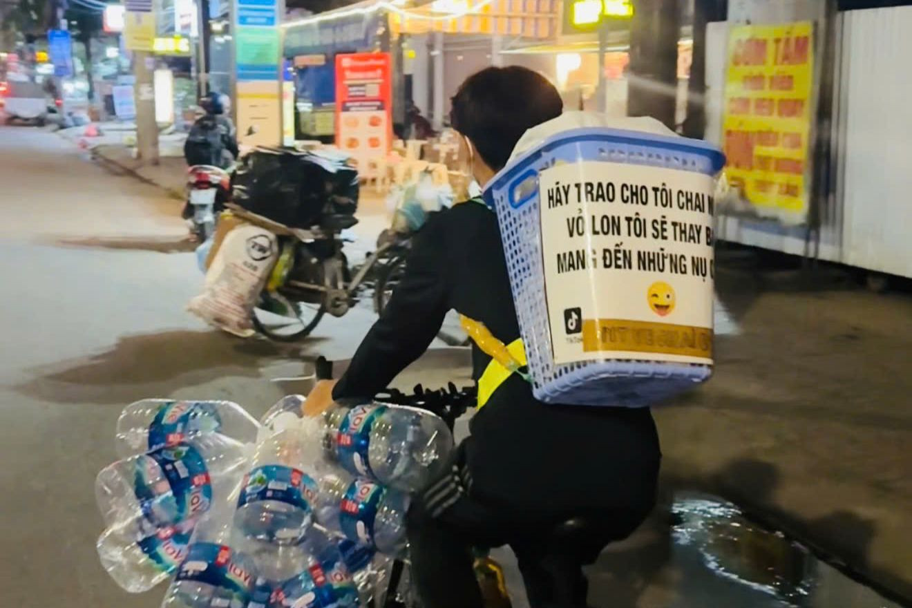 Chiếc xe đạp với dòng chữ “Hãy trao cho tôi chai nhựa, vỏ lon, tôi sẽ thay bạn mang đến những nụ cười”. Chiếc xe đạp với dòng chữ “Hãy trao cho tôi chai nhựa, vỏ lon, tôi sẽ thay bạn mang đến những nụ cười”.