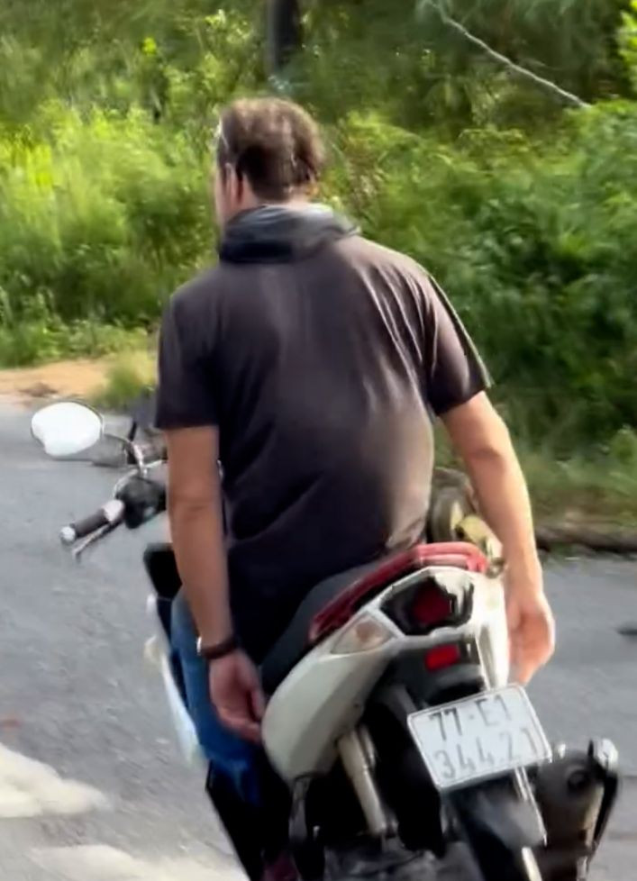 Một du khách nước ngoài buông cả hai tay lái. Ảnh cắt từ clip. Một du khách nước ngoài buông cả hai tay lái. Ảnh cắt từ clip.