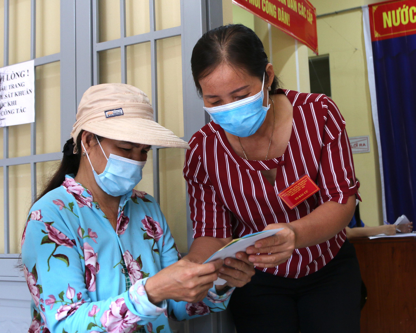 Tổ bầu cử hướng dẫn cho người dân biết những quy định để thực hiện đúng, đầy đủ quyền và nghĩa vụ của mình. - Ảnh: Nhật Huy.