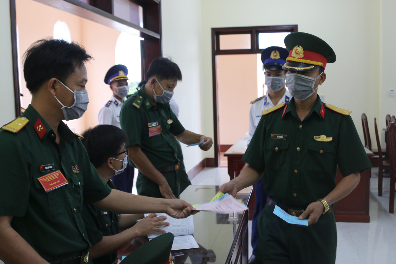 Sau khi được kiểm tra y tế, cử tri đưa thẻ cử tri để nhận phiếu bầu cử tại bàn hướng dẫn để được Tổ bầu cử hướng dẫn quy trình bỏ phiếu.