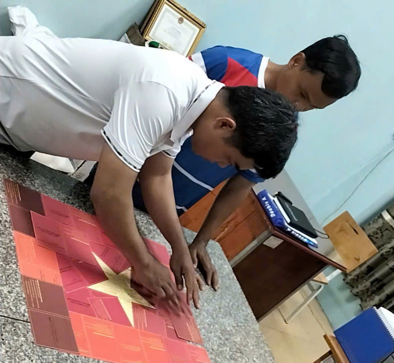 Thầy Nguyễn Minh Hoàng xếp cờ Tổ quốc bằng giấy chứng nhận hiến máu. Thầy Nguyễn Minh Hoàng xếp cờ Tổ quốc bằng giấy chứng nhận hiến máu.