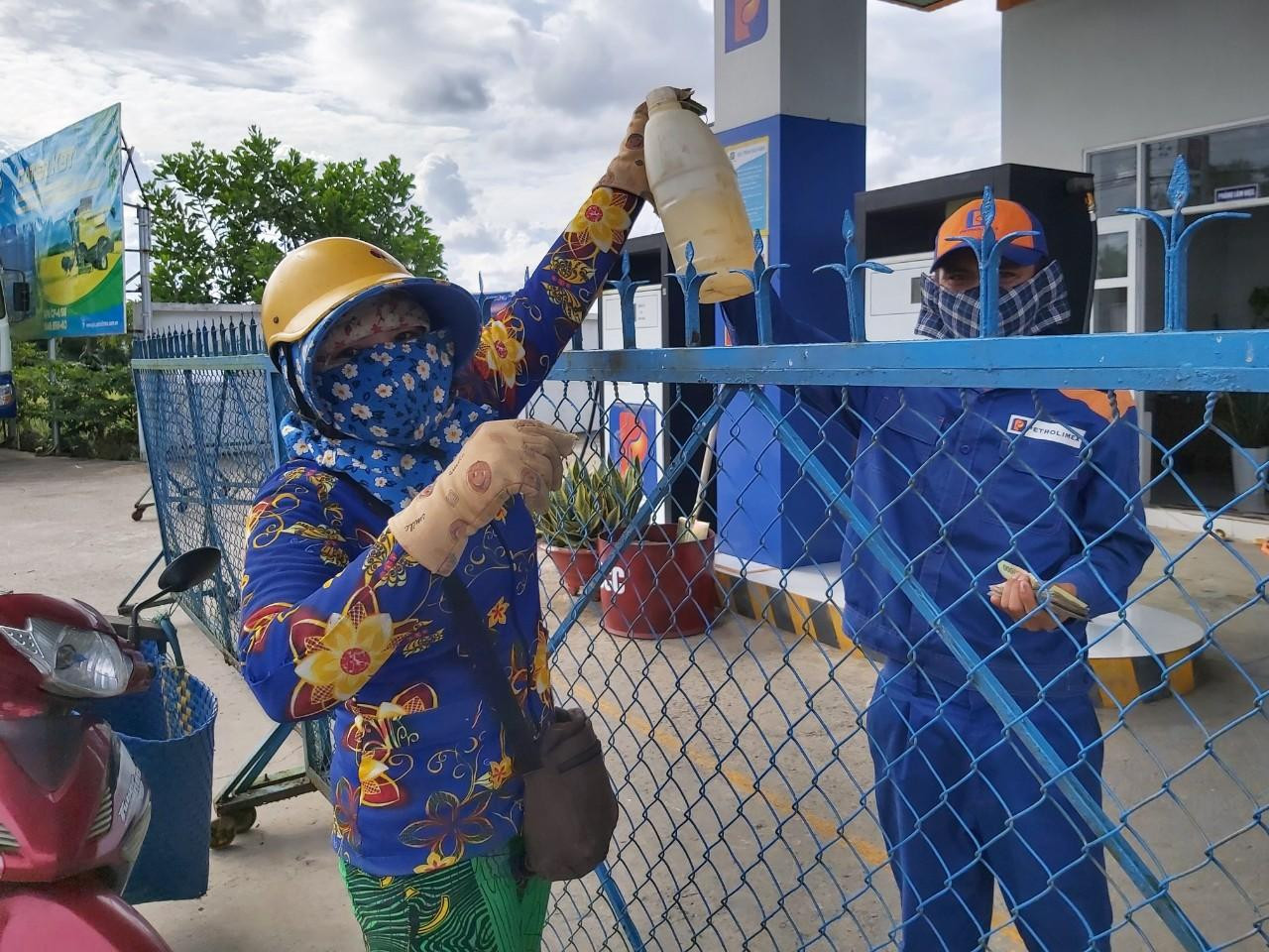 Người dân đem can nhựa đến mua.