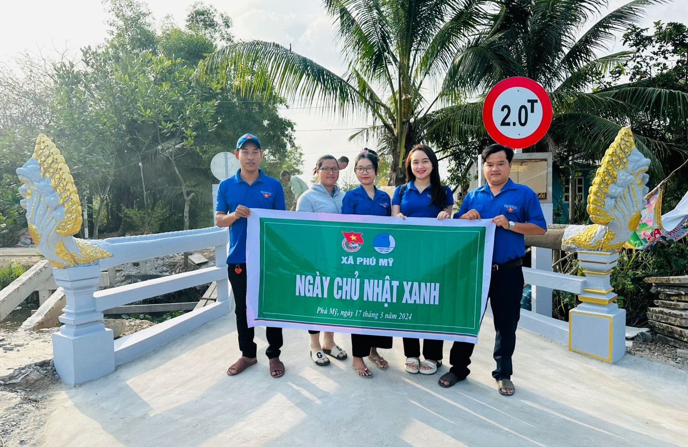 Anh Tấn (bên phải) cùng cây cầu nông thôn được anh vận động xây dựng.