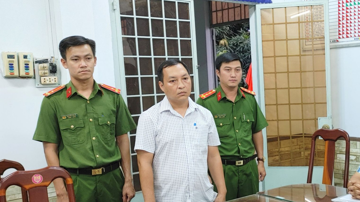 Cơ quan Công an đang tống đạt các quyết định khởi tố đối với bị can Ngô Hồng Việt Chương (áo trắng). Cơ quan Công an đang tống đạt các quyết định khởi tố đối với bị can Ngô Hồng Việt Chương (áo trắng).