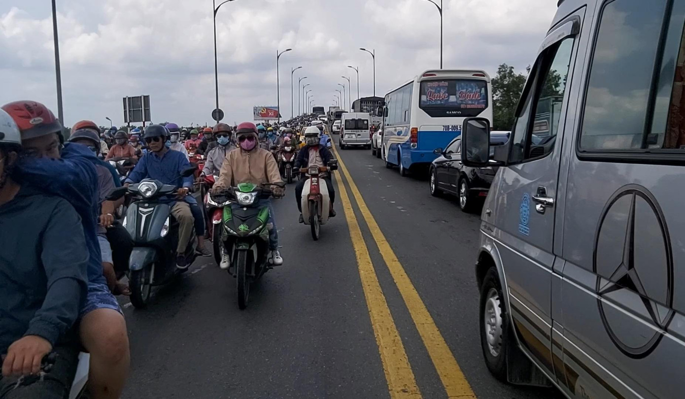 Đến 13 giờ cùng ngày, lượng phương tiện đổ về cầu Rạch Miễu chưa giảm, phương tiện vẫn nhích từng chút một qua cầu.