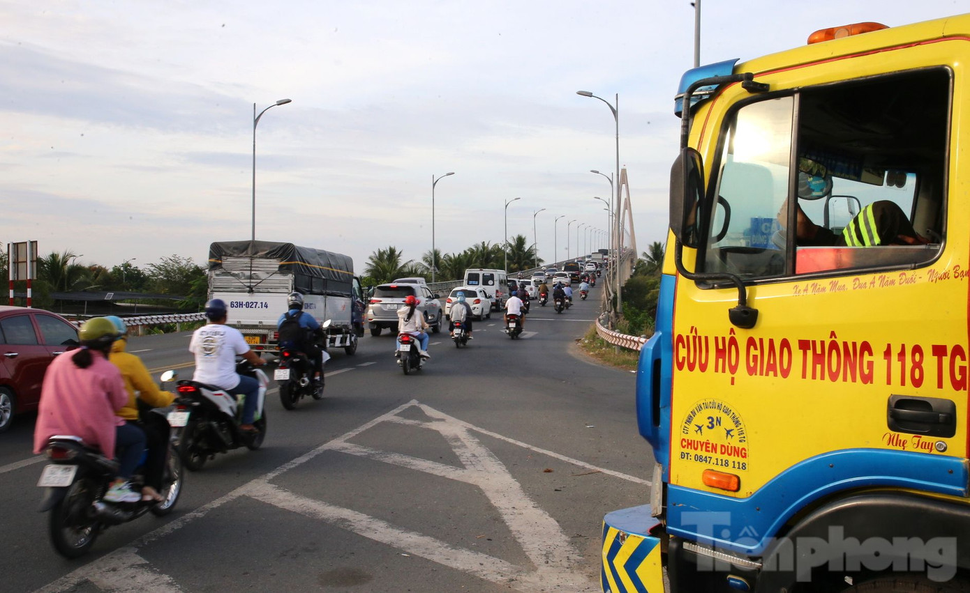 Lực lượng cứu hộ giao thông của công ty cứu hộ giao thông 118TG túc trực ở chân cầu Rạch Miễu giải cứu xe ô tô hư hỏng, tránh ùn tắc.