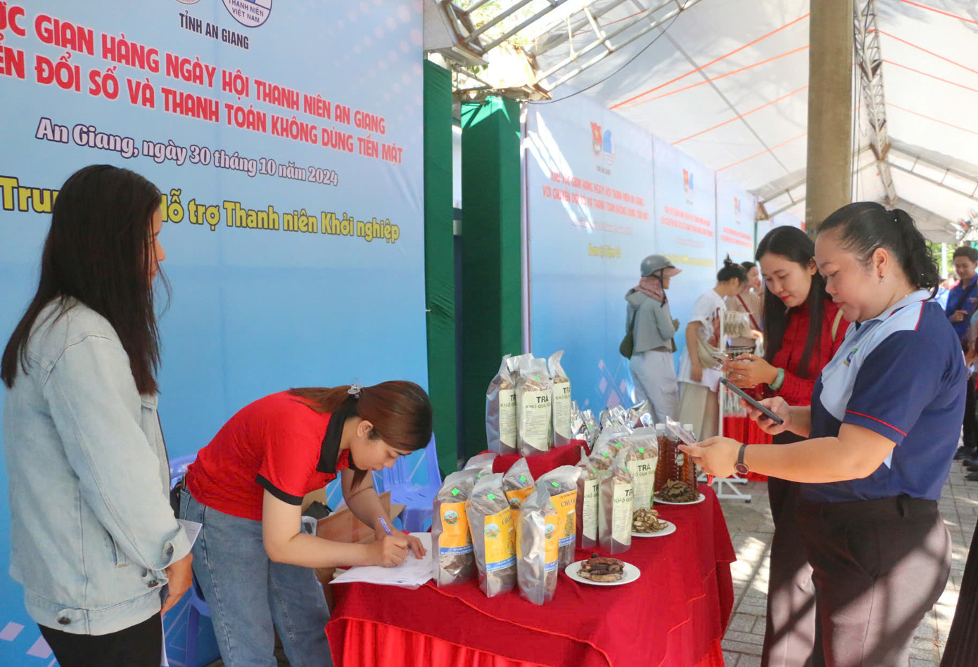 Đại biểu và người dân trải nghiệm thanh toán không tiền mặt khi mua các sản phẩm OCOP, sản phẩm khởi nghiệp của thanh niên tỉnh An Giang. Đại biểu và người dân trải nghiệm thanh toán không tiền mặt khi mua các sản phẩm OCOP, sản phẩm khởi nghiệp của thanh niên tỉnh An Giang.