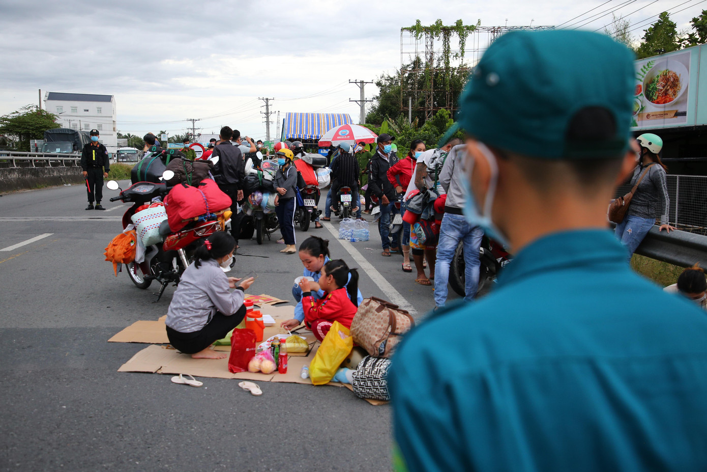 Do bị kẹt trong thời gian dài, người dân ngồi chờ ở ven đường để được cơ quan chức năng giải quyết.