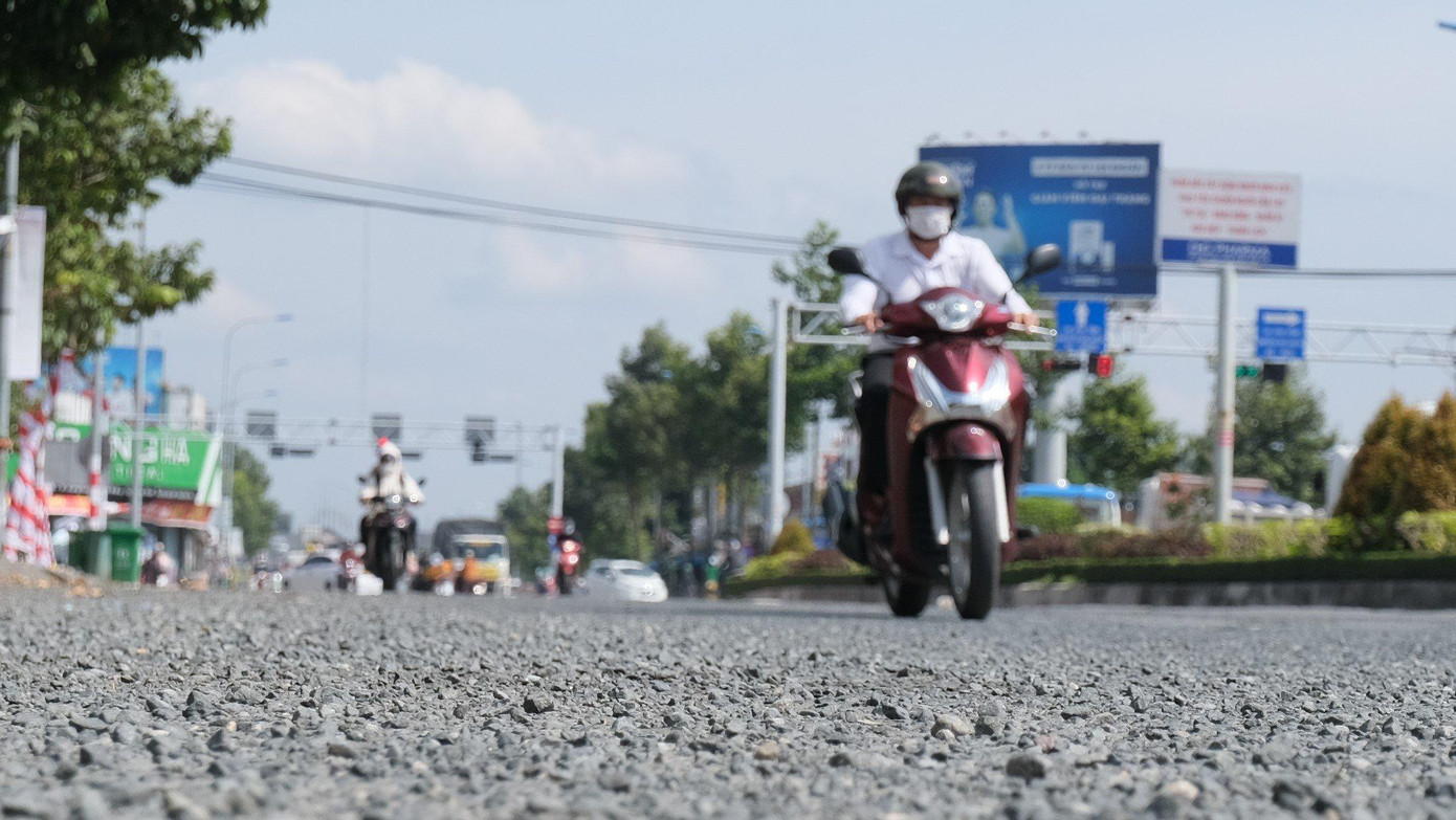 Đá dăm vương vãi trên mặt đường Võ Văn Kiệt khiến người dân bất an sau mỗi đợt triều cường.