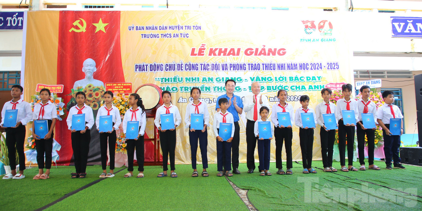 Anh Nguyễn Tường Lâm - Bí thư Trung ương Đoàn và ông Võ Nguyên Nam - Trưởng Ban Dân vận Tỉnh uỷ An Giang trao học bổng cho học sinh.