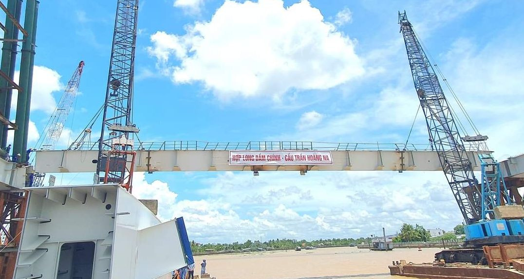 Dầm dọc bằng thép, nặng 150 tấn, dài 53m được đưa lên nhịp giữa cầu Trần Hoàng Na, trưa 26/8. Dầm dọc bằng thép, nặng 150 tấn, dài 53m được đưa lên nhịp giữa cầu Trần Hoàng Na, trưa 26/8.