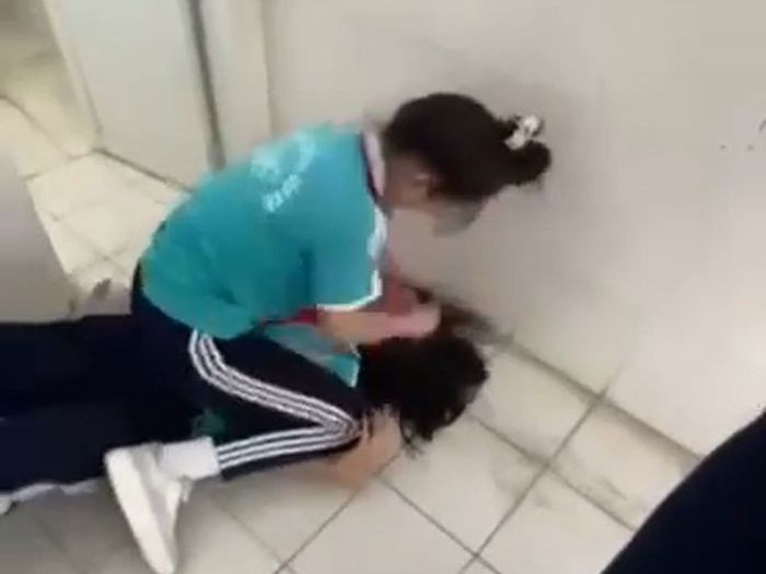 Nữ sinh đánh nhau trong nhà vệ sinh. Ảnh cắt từ clip.