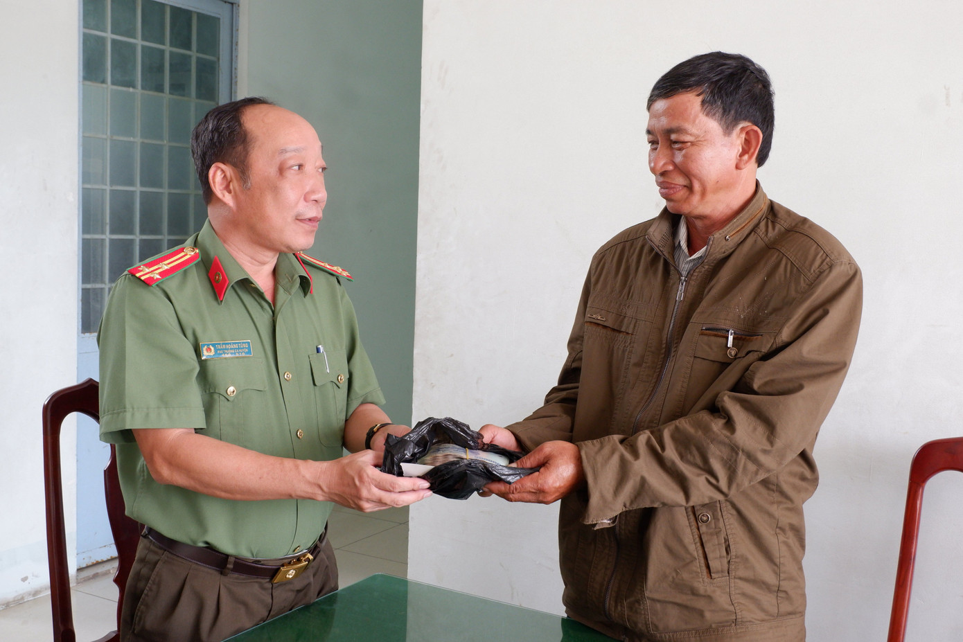 Thượng tá Trầm Hoàng Tùng – Phó Trưởng Công an huyện U Minh Thượng (Kiên Giang) tiếp nhận số tiền do ông Lê Văn Tổng nhặt được để trả lại người đánh rơi.