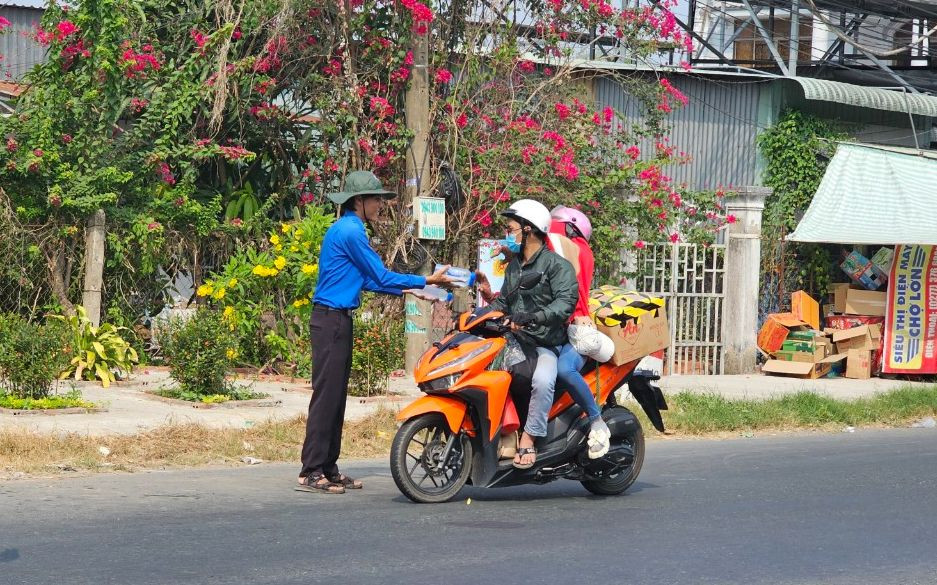Đoàn viên thanh niên tình nguyện tham gia phát nước miễn phí cho người dân về quê ăn Tết.