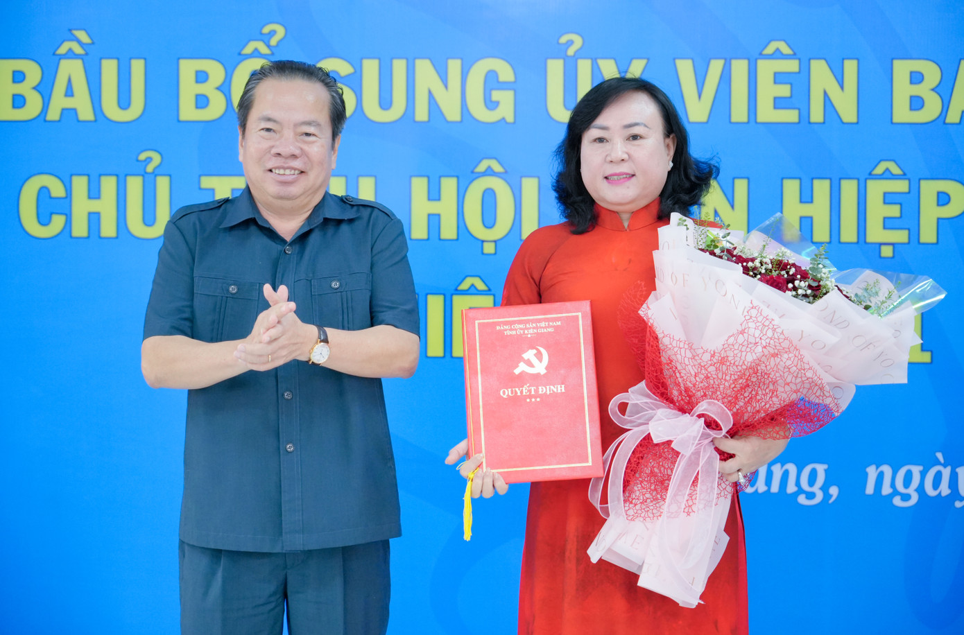 Ông Mai Văn Huỳnh trao quyết định, tặng hoa cho bà Trần Thu Hồng.