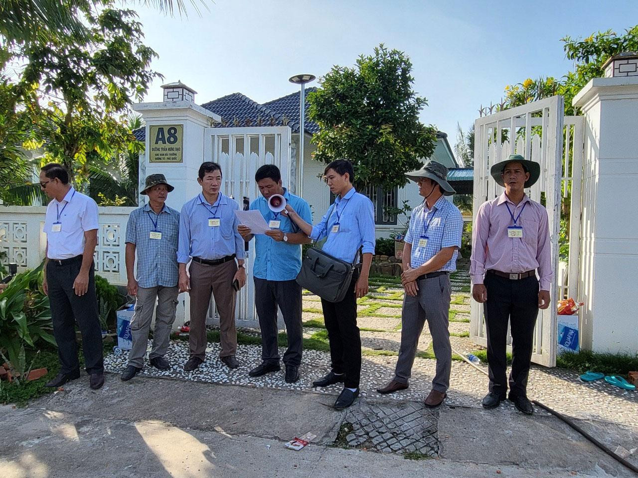 Cơ quan chức năng đọc quyết định cưỡng chế 2/79 căn biệt thự. Ảnh: H.T. Cơ quan chức năng đọc quyết định cưỡng chế 2/79 căn biệt thự. Ảnh: H.T.