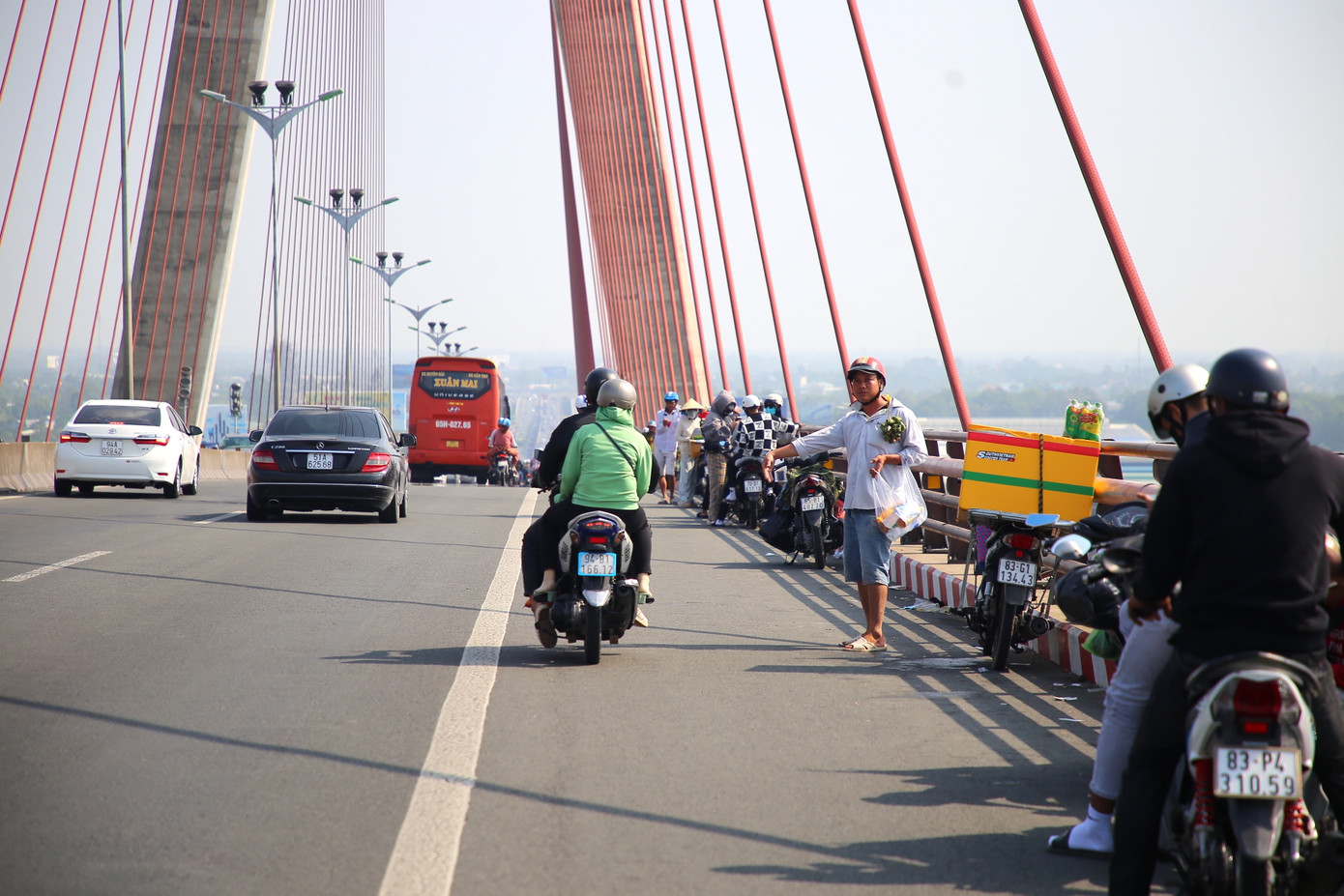 Trên cầu Cần Thơ, nhiều người dừng xe để nghỉ ngơi, chụp ảnh, trong khi một số hàng rong bày bán nước và đặc sản, lấn chiếm phần đường dành cho xe máy. Mặc dù chưa xảy ra ùn tắc, nhưng tình trạng này tiềm ẩn nguy cơ tai nạn giao thông.