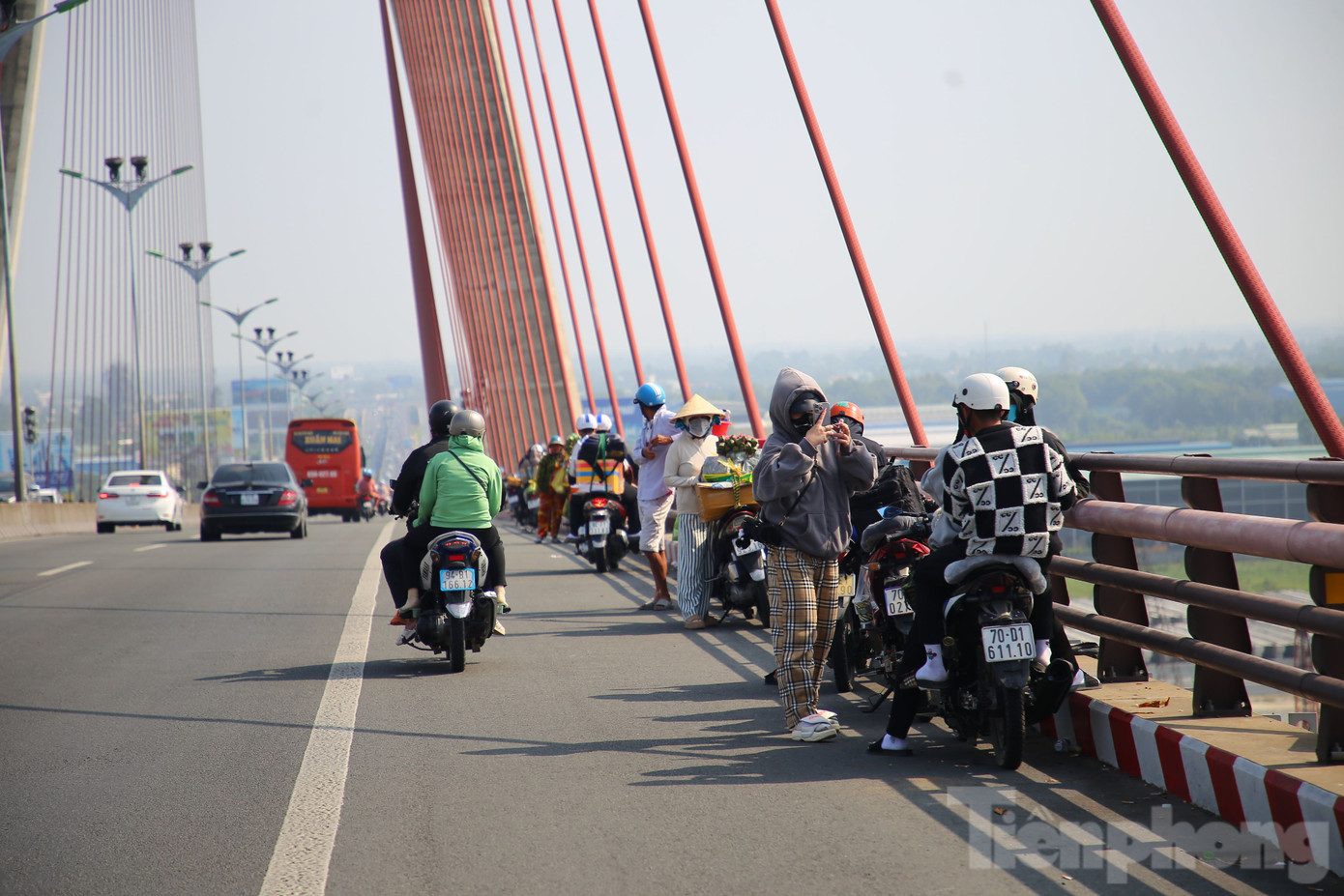 Trên cầu Cần Thơ, nhiều người dừng xe để nghỉ ngơi, chụp ảnh, trong khi một số hàng rong bày bán nước và đặc sản, lấn chiếm phần đường dành cho xe máy. Mặc dù chưa xảy ra ùn tắc, nhưng tình trạng này tiềm ẩn nguy cơ tai nạn giao thông.