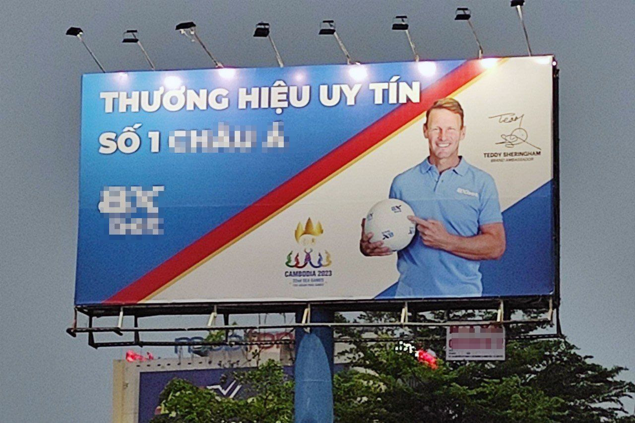 Tấm bảng ghi rõ dòng chữ "Thương hiệu uy tín số 1 châu Á...". Bên dưới bảng là logo Seagame 23 sắp diễn ra tại Campuchia, kèm theo là hình người đàn ông ôm quả bóng… đang quảng bá cho trang website cá độ bóng đá