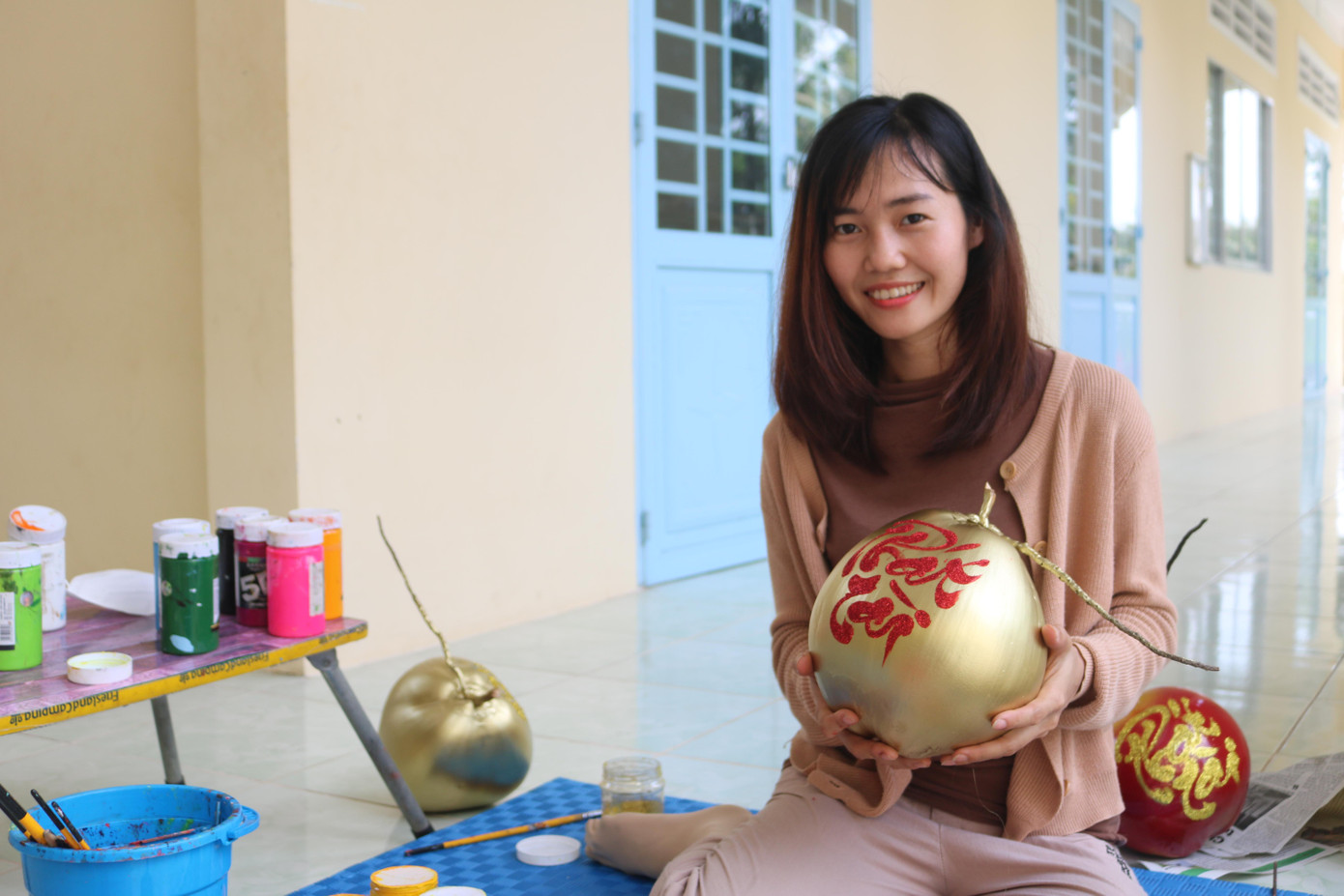 Cô giáo trẻ khoác lên những quả dừa “chiếc áo mới” bởi đôi tay khéo léo của mình.