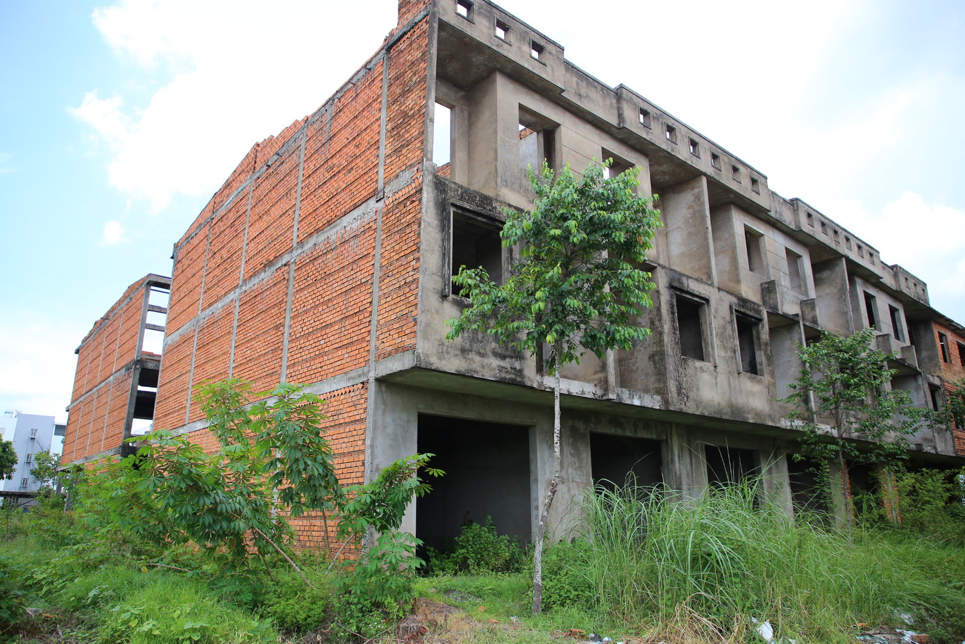 Ghi nhận của phóng viên ngày 9/5, tại khu dân cư 586 (thuộc khu đô thị Nam Cần Thơ), hàng loạt biệt thự, nhà phố… chủ đầu tư chỉ xây dựng phần thô rồi nằm bất động trong thời gian dài khiến cỏ mọc um tùm.