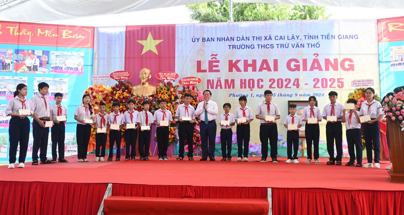 Trưởng Ban Tuyên giáo Trung ương - Nguyễn Trọng Nghĩa trao học bổng cho các em học sinh.