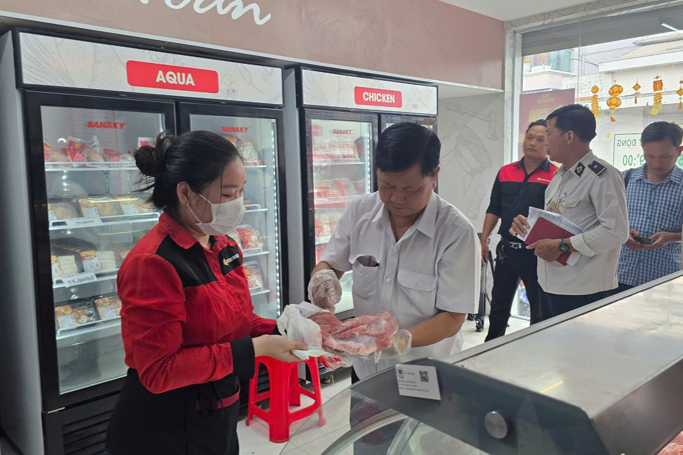 Lực lượng chức năng kiểm tra sản phẩm từ thịt heo tại cửa hàng C.P Fresh Shop tại thị trấn Mỹ Xuyên (huyện Mỹ Xuyên, tỉnh Sóc Trăng) chiều 30/5. Ảnh: Nhật Huy.