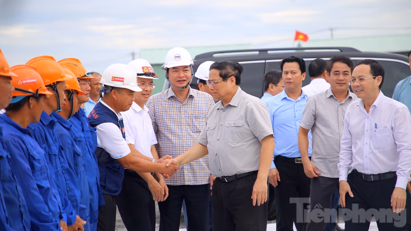 Tại công trường, Thủ tướng Phạm Minh Chính thăm hỏi, tặng quà và động viên những công nhân đang làm việc trước khi nghe báo cáo tình hình xây dựng dự án cao tốc Châu Đốc - Cần Thơ - Sóc Trăng. Ảnh: Nhật Huy.