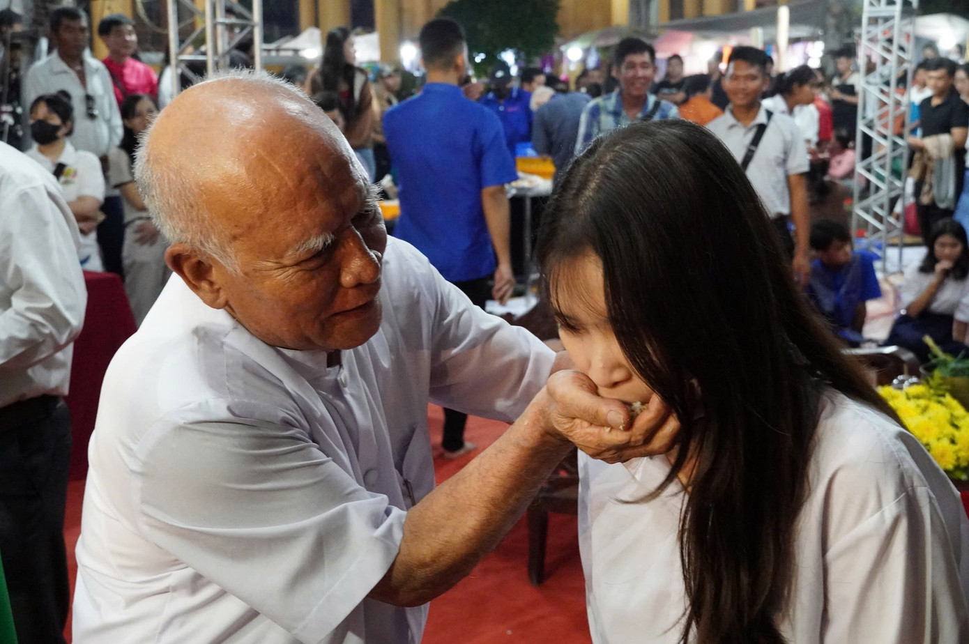 Nghi thức đút cốm dẹp tại lễ cúng trăng của đồng bào Khmer Sóc Trăng.