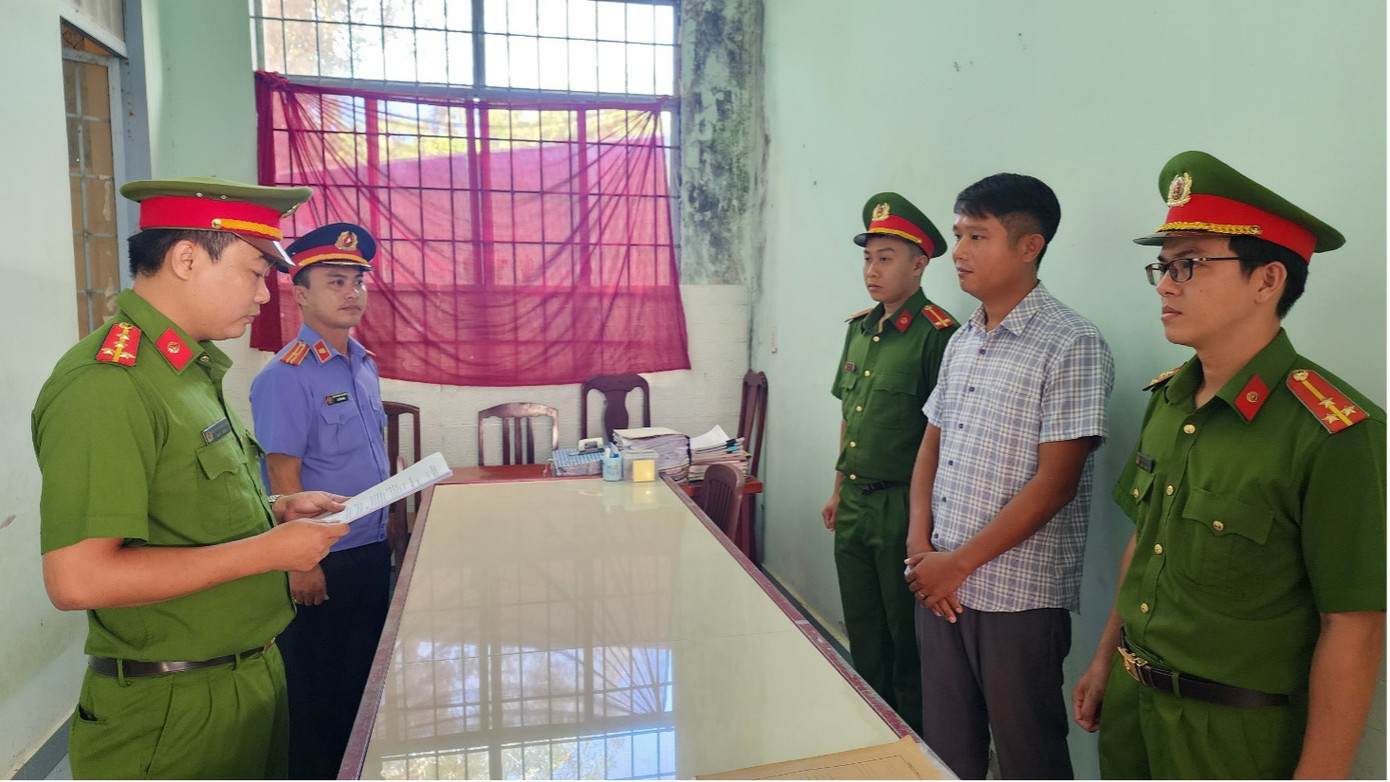 Điều tra viên tống đạt lệnh bắt tạm giam 4 tháng đối với Lê Minh Điệp (áo sơ mi sọc).