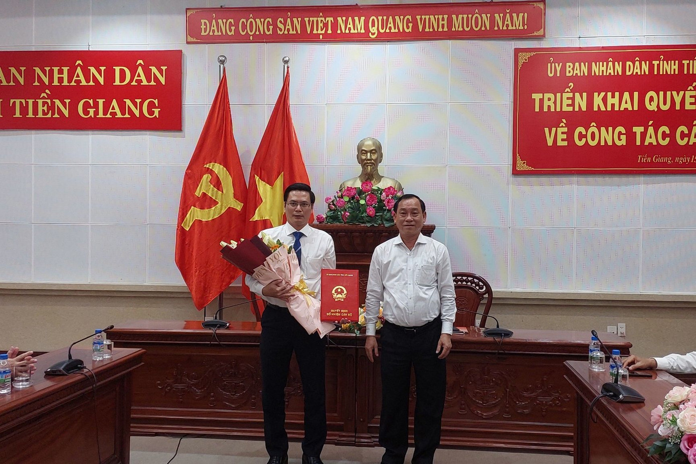 Ông Nguyễn Văn Vĩnh - Chủ tịch UBND tỉnh Tiền Giang trao quyết định và tặng hoa cho ông Hà Thiện Ý.