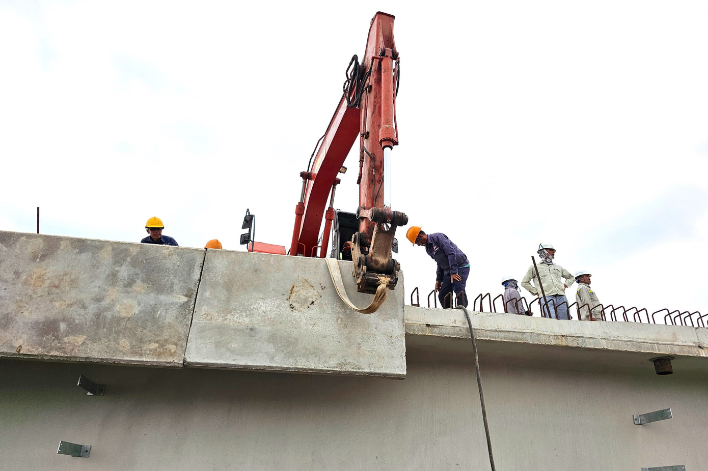 Những ngày cuối tháng 3, dưới cái nắng gay gắt giữa mùa khô miền Tây, nhiều công nhân vẫn miệt mài trên công trường cầu Đại Ngãi 2. Ghi nhận của PV Tiền Phong ngày 25/3, không khí lao động hối hả, công nhân tất bật với các công đoạn hoàn thiện cầu. Phía đầu cầu, nhóm kỹ sư gia cố các hạng mục kết nối với đường Nam Sông Hậu. Dưới gầm cầu, tổ kiểm tra kết cấu làm việc không ngừng nghỉ, đảm bảo chất lượng công trình.
