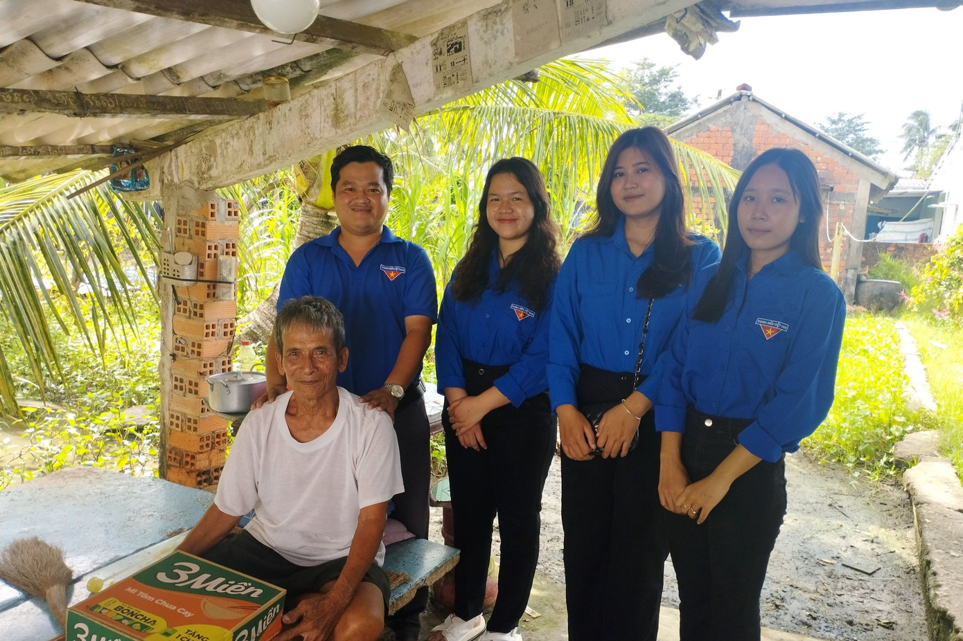 Anh Tấn (đứng bên trái) thăm hỏi, tặng quà những người già yếu, bệnh tật có hoàn cảnh khó khăn.