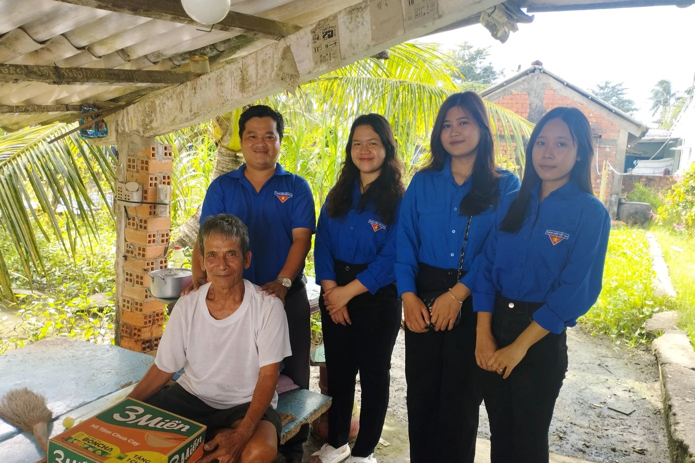 Anh Tấn (đứng bên trái) thăm hỏi, tặng quà những người già yếu, bệnh tật có hoàn cảnh khó khăn.