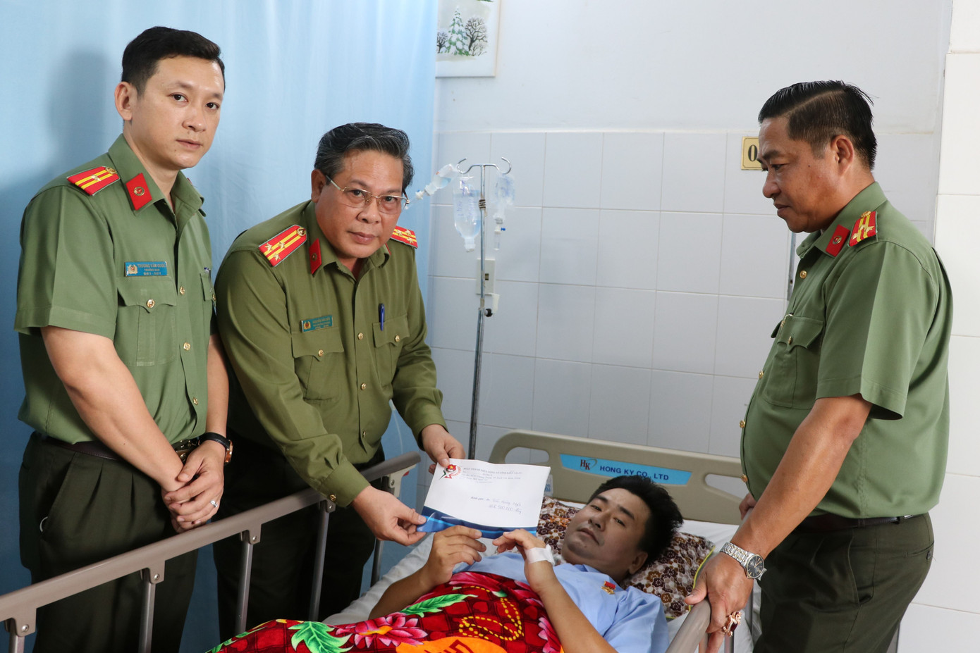 Đoàn công tác Công an tỉnh Kiên Giang đến thăm hỏi, trao số tiền gần 200 triệu đồng cho đại uý Ngôi. Ảnh: CAKG.