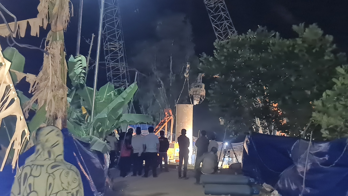 Một ống thép lớn được lồng vào trụ bê tông nơi cháu bé lọt vào để nhổ trụ lên mặt đất.