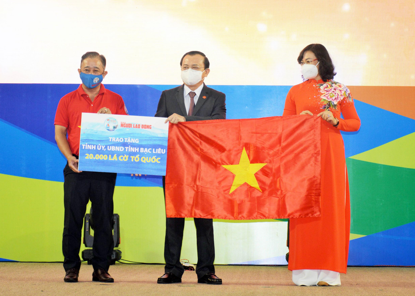 Bà Phan Thị Thắng, Phó Chủ tịch UBND TP. HCM và ông Bùi Thanh Liêm (bìa trái), Phó Tổng Biên tập Báo Người Lao Động, trao cờ Tổ quốc và bảng tượng trưng 20.000 lá cờ cho ông Lê Tấn Cận, Phó Chủ tịch UBND tỉnh Bạc Liêu.