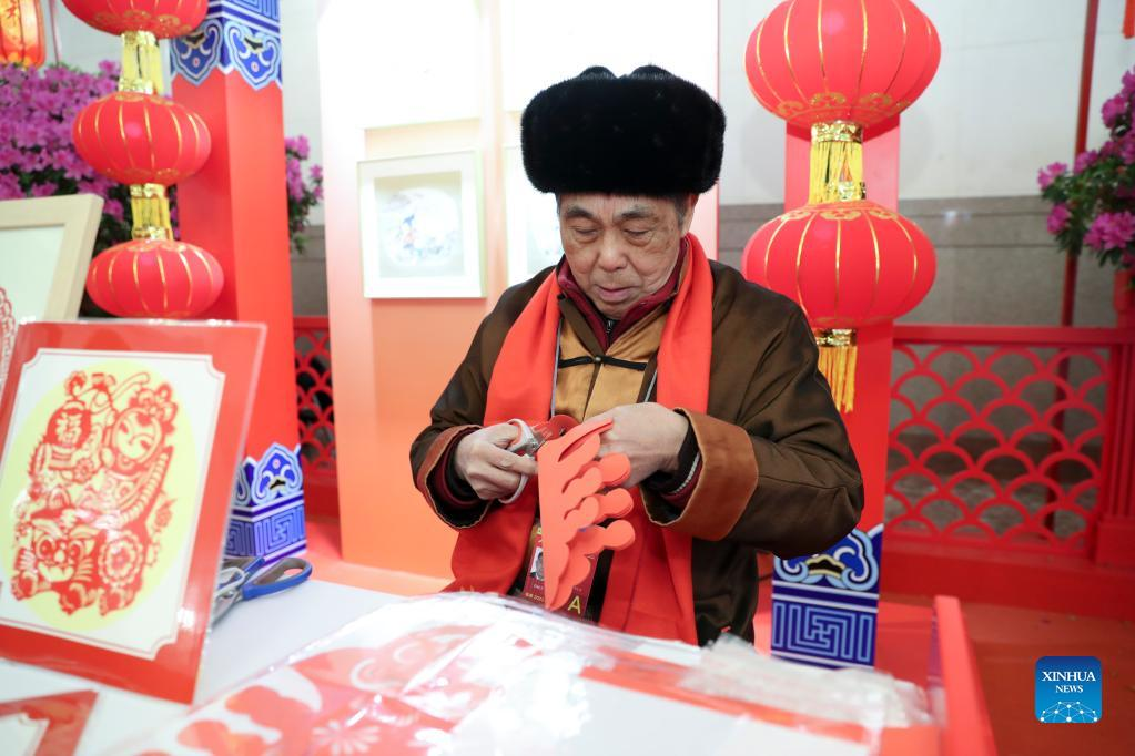 Một nghệ nhân biểu diễn cắt giấy trước sự chứng kiến của quan khách. Ảnh: Tân Hoa Xã Một nghệ nhân biểu diễn cắt giấy trước sự chứng kiến của quan khách. Ảnh: Tân Hoa Xã