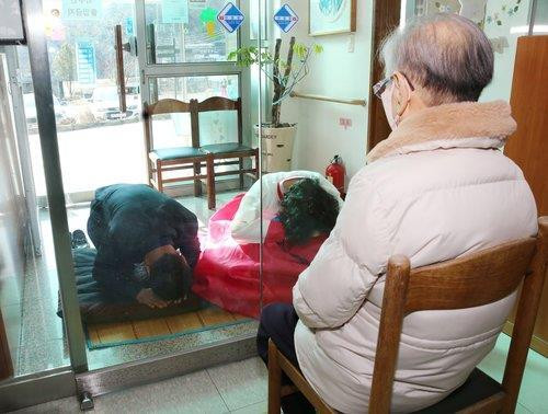 Bức ảnh được chụp ngày 31/1, ghi lại cảnh 2 người con hành lễ mừng năm mới với mẹ tại một viện dưỡng lão ở tỉnh Bắc Gyeongsang. Giữa họ có một tấm kính để hạn chế nguy cơ lây lan COVID-19. Ảnh: Yonhap Bức ảnh được chụp ngày 31/1, ghi lại cảnh 2 người con hành lễ mừng năm mới với mẹ tại một viện dưỡng lão ở tỉnh Bắc Gyeongsang. Giữa họ có một tấm kính để hạn chế nguy cơ lây lan COVID-19. Ảnh: Yonhap