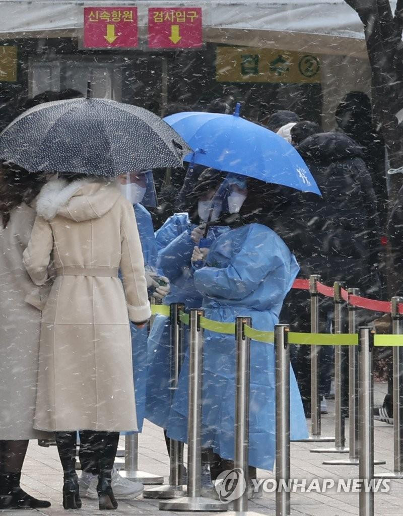 Người dân Seoul đi xét nghiệm dưới trời mưa tuyết. Ảnh: Yonhap Người dân Seoul đi xét nghiệm dưới trời mưa tuyết. Ảnh: Yonhap