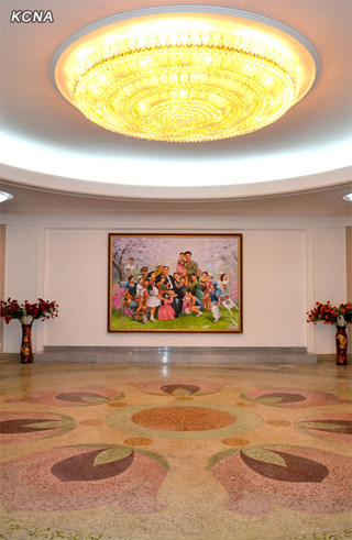 Một căn phòng lớn trong khu nhà ở cao cấp, với bức vẽ ông Kim Nhật Thành và ông Kim Jong-il được các em thiếu nhi vây quanh. Ảnh: KCNA Một căn phòng lớn trong khu nhà ở cao cấp, với bức vẽ ông Kim Nhật Thành và ông Kim Jong-il được các em thiếu nhi vây quanh