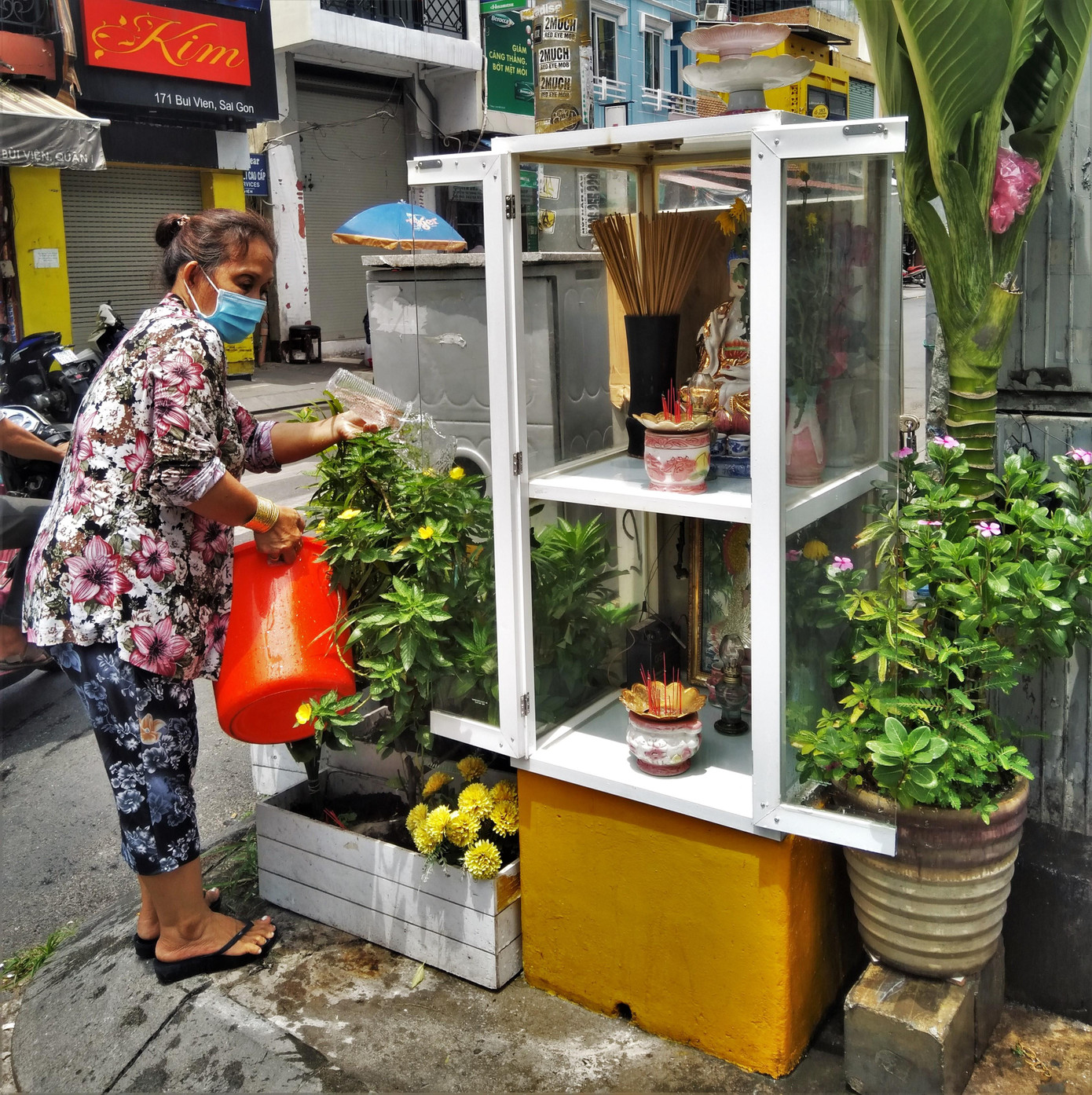 Một người dân chăm sóc tượng thờ thần tài trên phố Bùi Viện với mong ước dịch bệnh sớm được khống chế để con phố này lại đông vui.