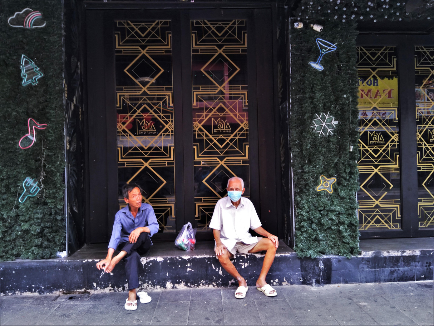 Bác Hạnh (phải) 85 tuổi nhà trong hẻm ra phố ngồi hóng mát. Bác cho biết: "Tôi chưa bao giờ thấy phố xá vắng tanh như bây giờ. Mọi người đã đi đâu hết cả rồi".